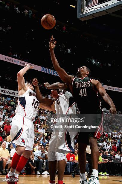 Kurt Thomas of the Milwaukee Bucks goes after a loose ball over Mike Bibby and Joe Johnson of the Atlanta Hawks in Game Seven of the Eastern...