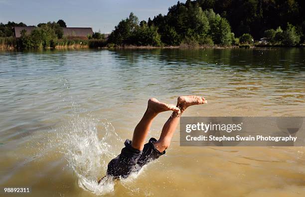 a boy diving into a lake - newhealth foto e immagini stock