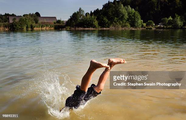 a boy diving into a lake - newhealth ストックフォトと画像