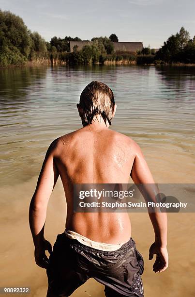 boy preparing to dive into lake. - newhealth stock pictures, royalty-free photos & images