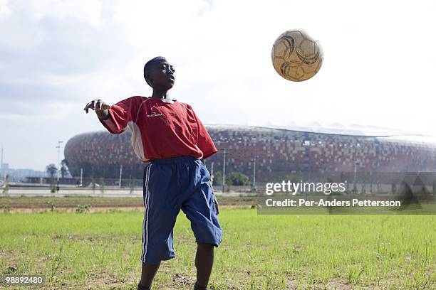 Soccer player in a youth team practice on a field in front of Soccer City on January 16 in Johannesburg, South Africa. This young player...