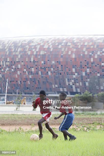 Players in a youth team practice on a field in front of Soccer City on January 16 in Johannesburg, South Africa. These young players practice several...