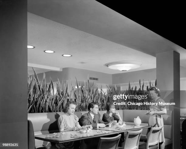 Interior view of the Blackstone Hotel, showing three people sitting at a booth, with a waitress standing beside them, Omaha, NE, 1941. The hotel was...