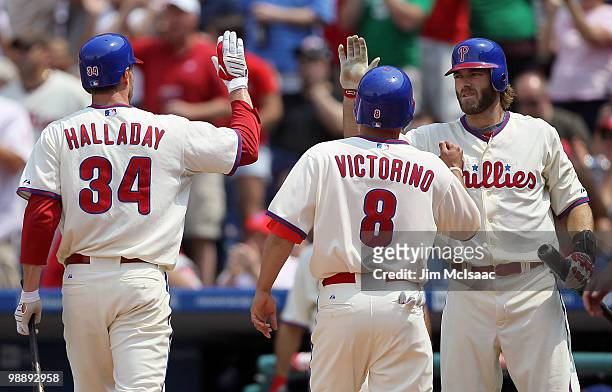 Jayson Werth of the Philadelphia Phillies congratultaes teammates Roy Halladay and Shane Victorino after they scored in the second inning against the...