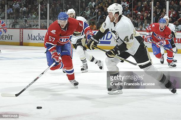 Benoit Pouliot of the Montreal Canadiens skates with the puck in front of Brooks Orpik of the Pittsburgh Penguins in Game Three of the Eastern...