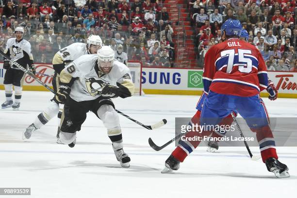 Pascal Dupuis of the Pittsburgh Penguins skates to reach the puck in front of Hal Gill of Montreal Canadiens in Game Three of the Eastern Conference...