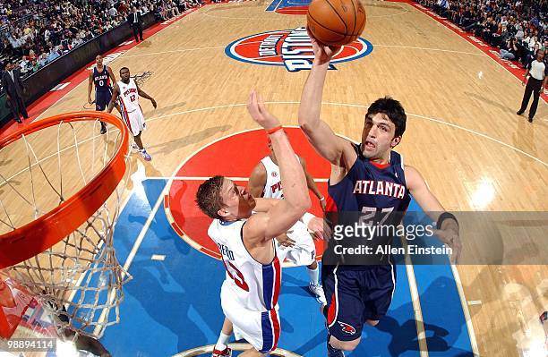 Zaza Pachulia of the Atlanta Hawks takes a shot against Jonas Jerebko of the Detroit Pistons during the game at the Palace of Auburn Hills on April...