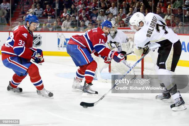 Alex Goligoski of the Pittsburgh Penguins attempts to clear the puck in front of Glen Metropolit and Travis Moen of the Montreal Canadiens in Game...