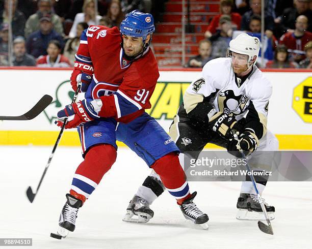 Scott Gomez of the Montreal Canadiens stick handles the puck while being defended by Jordan Leopold of the Pittsburgh Penguins in Game Four of the...