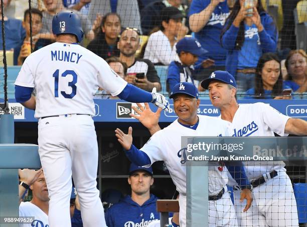 Max Muncy is congratulated by manager Dave Roberts of the Los Angeles Dodgers after hitting a solo home run in the first inning of the game off Kyle...