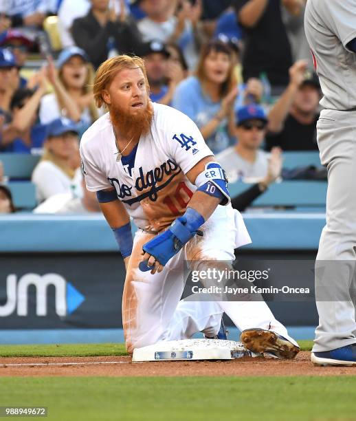 Justin Turner of the Los Angeles Dodgers is safe at third in the game against the Chicago Cubs at Dodger Stadium on June 27, 2018 in Los Angeles,...