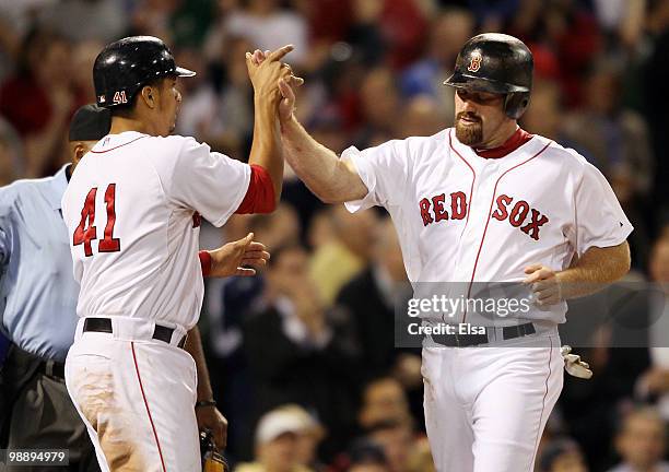 Kevin Youkilis of the Boston Red Sox is congratulated by teammate Victor Martinez after they both score in the fifth inning against the Los Angeles...