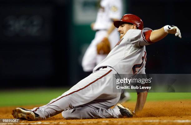 Adam LaRoche of the Arizona Diamondbacks slides safely into third base after hitting a triple in the fifth inning against the Houston Astros as third...