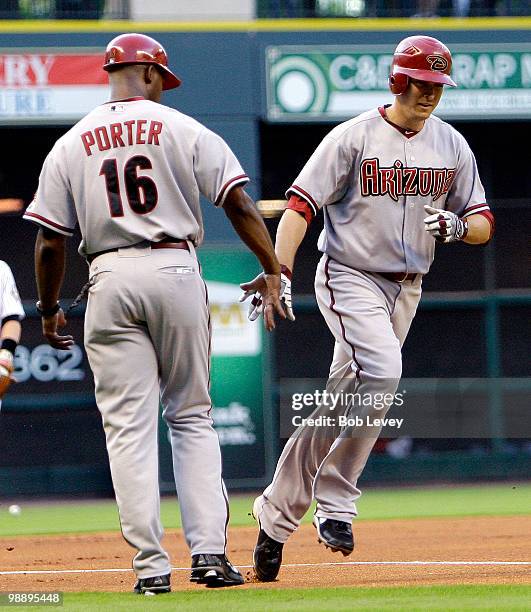 Kelly Johnson of the Arizona Diamondbacks is congratulated by third base coach Bo Porter after hitting a home run in the first inning off of pitcher...