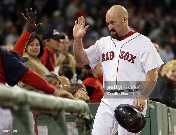 Kevin Youkilis of the Boston Red Sox celebrates with teammates in the dugout after he scored in the sixth inning against the Los Angeles Angels of...