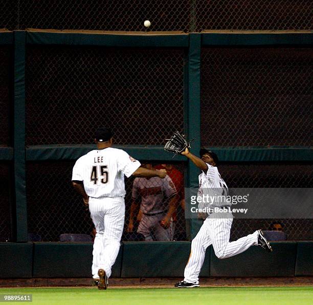 Center fielder Michael Bourn of the Houston Astros makes a catch behind left fielder Carlos Lee in the fifth inning against the Arizona Diamondbacks...