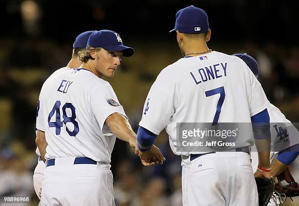 Starting pitcher John Ely of the Los Angeles Dodgers is congratulated by James Loney just before coming out of the game in the seventh inning against...