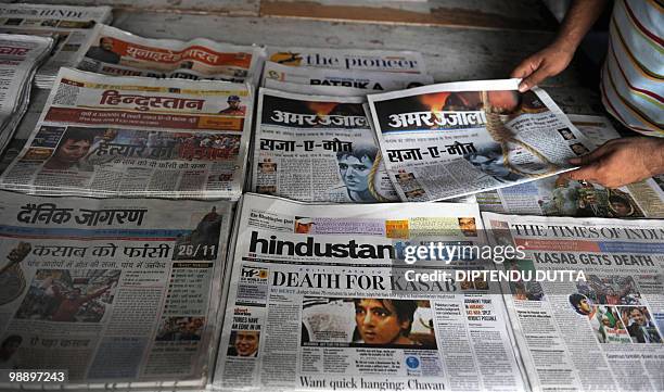 An Indian newspaper seller arranges newspapers at a stall carrying the stories of the death sentence verdict of Mohammed Ajmal Amir Kasab in...