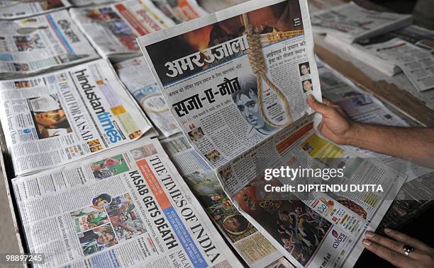 An Indian newspaper seller arranges newspapers at a stall carrying the stories of the death sentence verdict of Mohammed Ajmal Amir Kasab in...