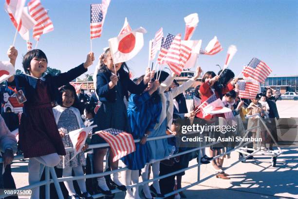 Well-wishers wave national flags as Crown Prince Akihito and Crown Princess Michiko arrive at the Joint Base Andrews on October 5, 1987 in Joint Base...