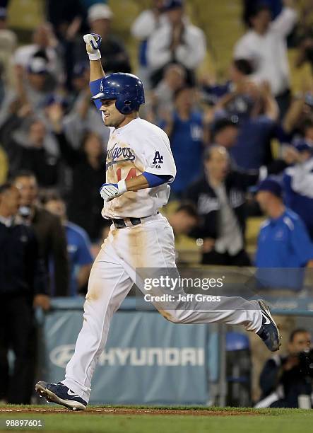 Jamey Carroll of the Los Angeles Dodgers celebrates as he crosses home plate after scoring on a walk-off grand slam by Andre Ethier in the ninth...