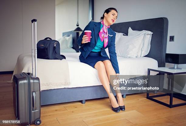 cabin crew member is massaging her tired leg after long flight - beautiful long legs imagens e fotografias de stock