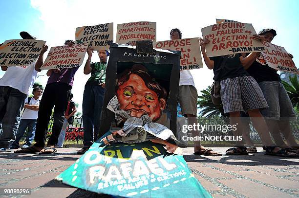 Activists hold banners next to a mock election counting machine during a protest in front of the Commission on Elections building in Manila on May 7,...