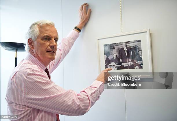 Michel Barnier, European Union internal market commissioner, gestures towards a framed photograph of French Foreign Minister Robert Schuman making...