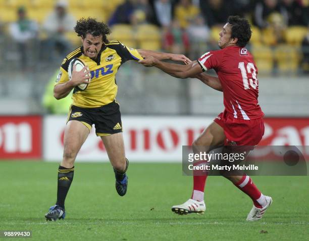 Jason Kawau of the Hurricanes is tackled by Will Chambers of the Reds during the round 13 Super 14 match between the Hurricanes and the Reds at...
