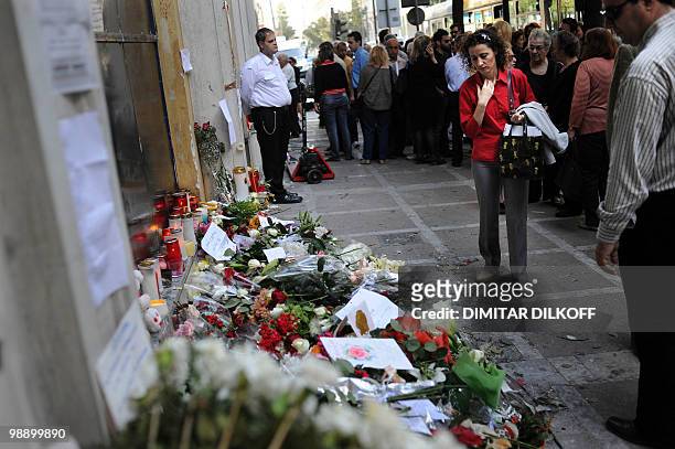 People mourn on May 7, 2010 in front a branch of the Marfin bank where three people were killed in Athens. A fire-bomb attack on a bank in Greece...