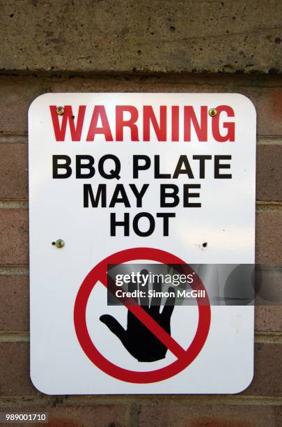 'warning: bbq plate may be hot' sign on an outdoor barbeque in a public park - hazardous area sign stock pictures, royalty-free photos & images