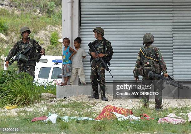 Soldiers guard a shuttered row of shops while two children look on in the southern Philippine province of Maguindanao on May 7 three days before...