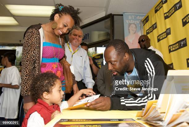 Wyclef Jean signs $50 Western Union gift cards at the Western Union "Returns The Love" To Moms at Money Mart on May 6, 2010 in San Francisco,...