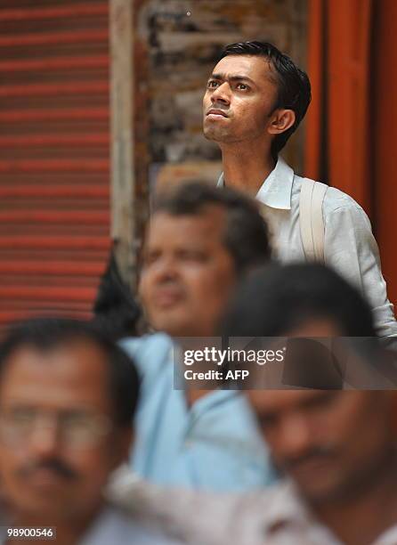 Indian men watch share prices on a digital brodcast board outside the Bombay Stock Exchange in Mumbai on May 7, 2010. Indian shares fell 1.73...