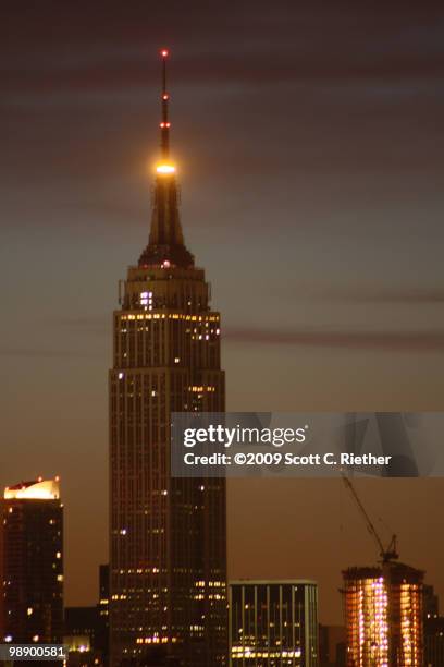 defining element - empire state building at night stock pictures, royalty-free photos & images