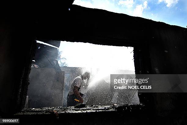 Fireman sprays water on his face after battling a fire that raced through a squatter area in Malabon, north of Manila on May 7, 2010. Around 100...