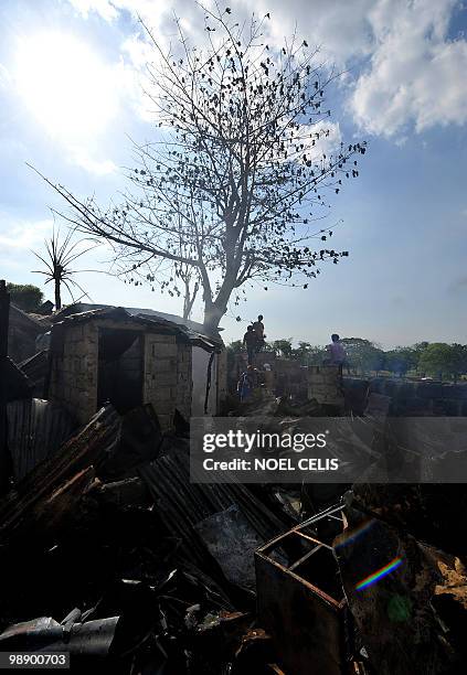 Smoke rises from the ruins as residents salvage their belongings in the debris after a fire raced through a squatter area in Malabon, north of Manila...