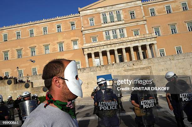 Masked protestor looks at a police cordon in front of the Greek Parliament in central Athens on May 6, 2010. More than 10,000 people demonstrated...