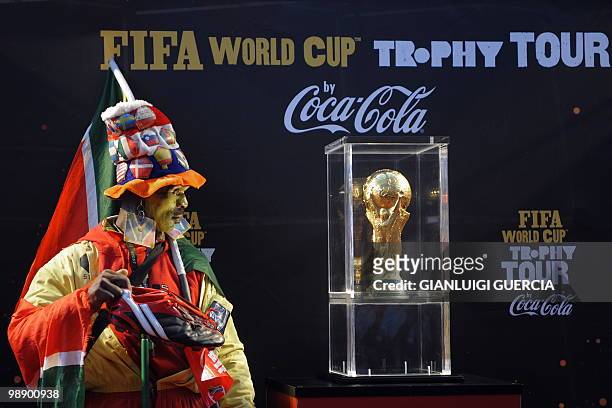 South African football entusiastic looks at the FIFA World Cup trophy as he waits on stage to have his picture taken after the unveiling of the FIFA...