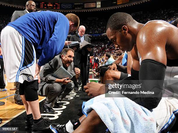 Dwight Howard listens as head coach Stan Van Gundy of the Orlando Magic encourages his players during a time out against the Atlanta Hawks in Game...