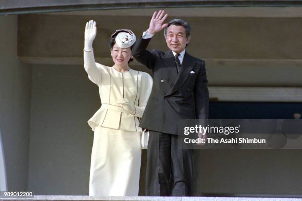 Crown Prince Akihito and Crown Princess Michiko wave to well-wishers in front of the Peace Memorial Hall at Okinawa Peace Memorial Park on October...