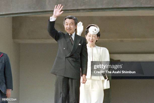 Crown Prince Akihito and Crown Princess Michiko wave to well-wishers in front of the Peace Memorial Hall at Okinawa Peace Memorial Park on October...