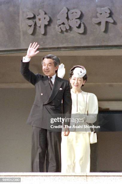 Crown Prince Akihito and Crown Princess Michiko wave to well-wishers in front of the Peace Memorial Hall at Okinawa Peace Memorial Park on October...