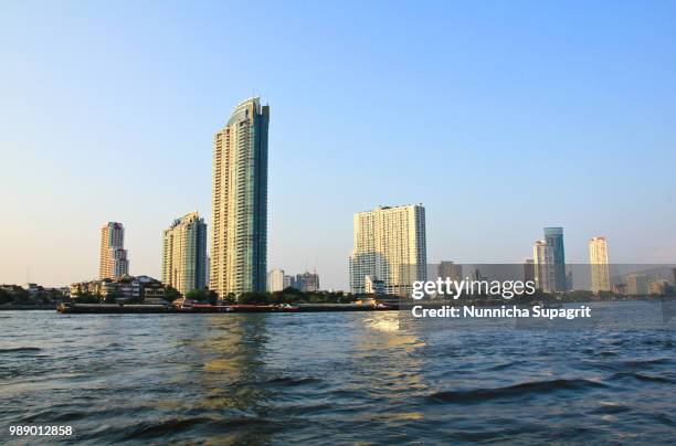 buildings along the river. the view from asiatique. - asiatique stock-fotos und bilder