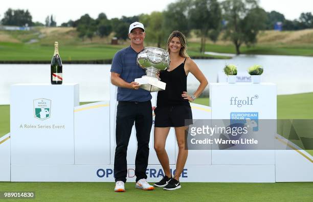 Alex Noren of Sweden poses with his wife Jennifer cand the trophy after winning the HNA Open de France at Le Golf National on July 1, 2018 in Paris,...