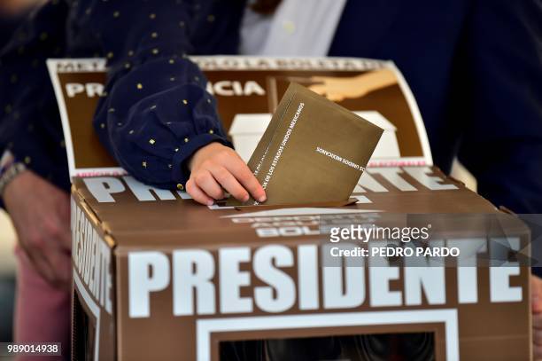 Carmen, the daughter of Mexico's presidential candidate Ricardo Anaya for the "Mexico al Frente" coalition party, holds the ballot before he casts...
