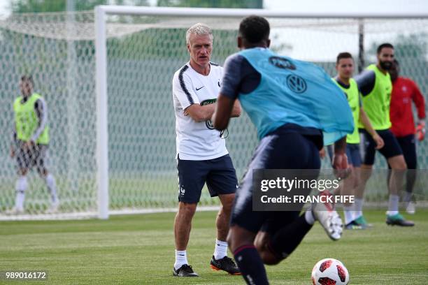 France's head coach Didier Deschamps watches his players during a training session at the Glebovets stadium in Istra, some 70 km west of Moscow, on...