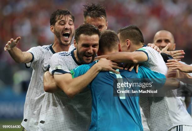 Vladimir Granat and Denis Cheryshev celebrates with goalkeeper Igor Akinfeev of Russia when they win the penalty shoot out during the 2018 FIFA World...