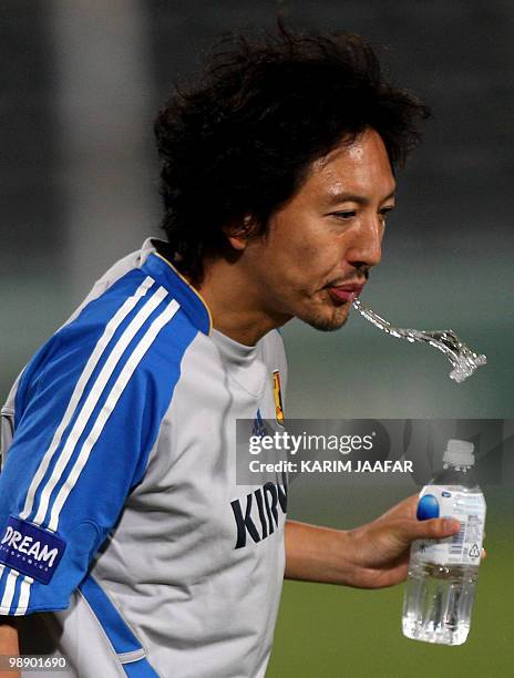 Japan's Yuki Abe spits water during a training session in Doha on November 16, 2008. Japan faces Qatar in a 2010 World Cup Asian qualifier on...