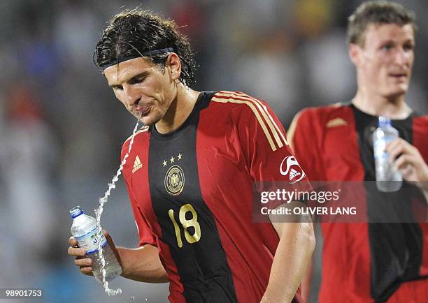 Germany's striker Mario Gómez spits out water after the friendly football match Germany vs United Arab Emirates in Dubai on June 2, 2009 during the...